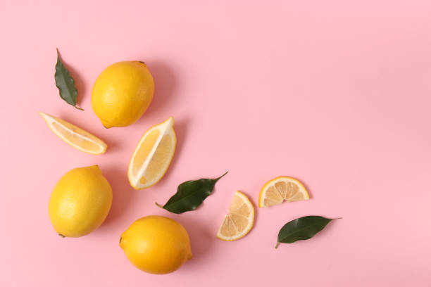 istock lemons and green leaves on a colored background. 1314274788