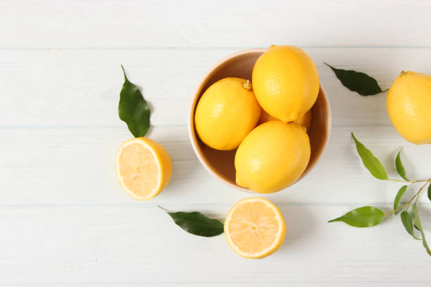 istock lemons and green leaves on a colored background. 1314275506