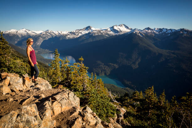 Female hiker looking at view of Cheakamus Lake from Whistler mountain. Mountain and lake views from High Note trail on Whistler mountain. garibaldi park stock pictures, royalty-free photos & images