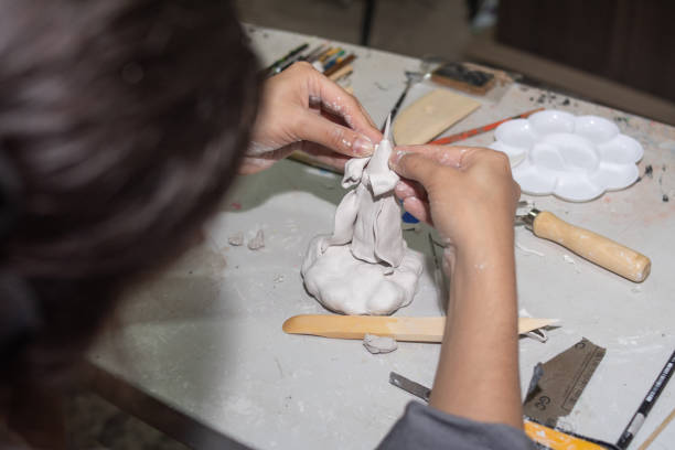 istock artisan hands molding a sculpture in clay and molding paste, on a table with several molding tools and brushes 1314278362
