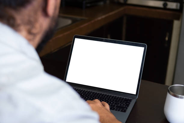 istock Young adult sitting in the kitchen using a laptop, working at home. 1314278473