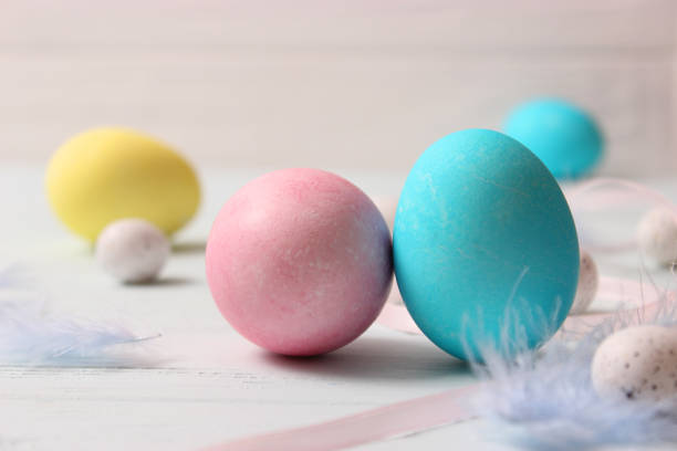 istock Easter composition of painted eggs and feathers on a colored background. 1314280564
