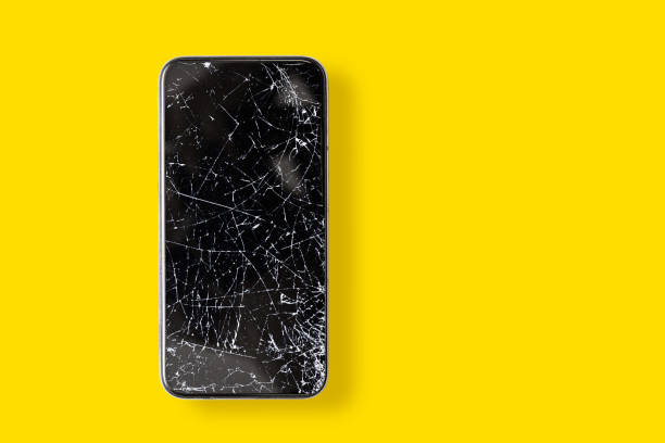istock Black broken touch screen phone on a yellow background. Phone with cracked screen 1314281316
