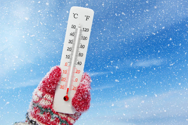 White celsius and fahrenheit scale thermometer in hand. Ambient temperature minus 28 degrees celsius stock photo
