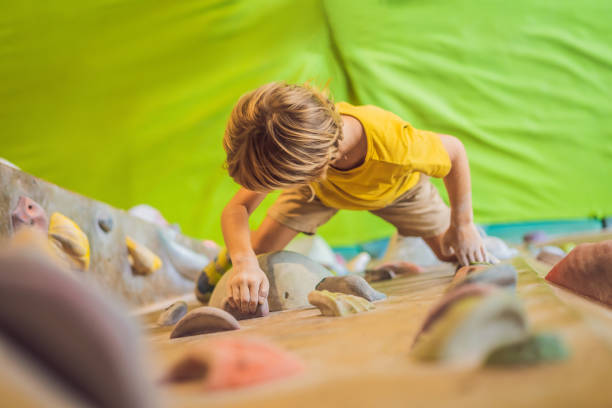 istock little boy climbing a rock wall in special boots. indoor 1314282968
