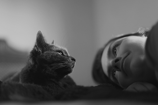 Woman and cat lying side by side.