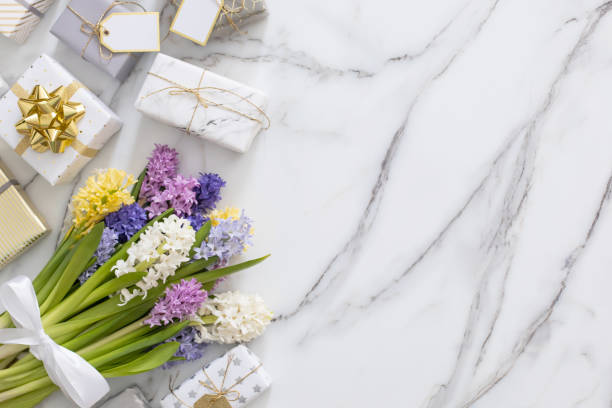istock Top view trendy composition with festive wrapped gift boxes ribbon bow decorated by bloom flowers 1314283160