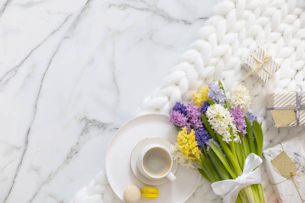 istock Top view composition with cup of coffee, pastry macarons and spring multicolored hyacinth on white fluffy knitted plaid 1314285560