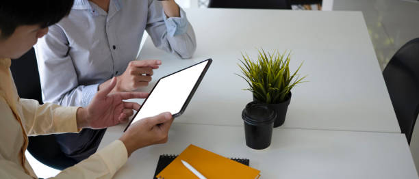 istock Two young business people using digital tablet and meeting for new project planning in office room. 1314294896