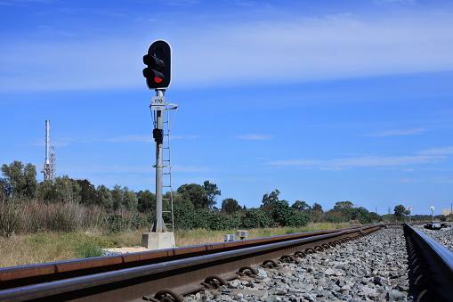 Railway signal on an empty rail way track near industrial site. No people. Copy space