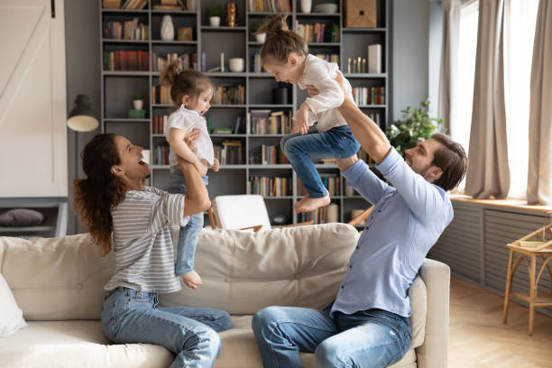 istock Happy parents play with excited little daughters 1314298983