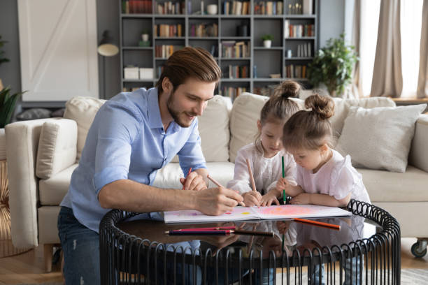 istock Loving dad drawing with two little daughters 1314298994