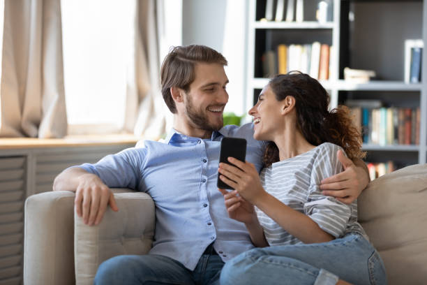 istock Happy couple relax on sofa using cellphone 1314299118