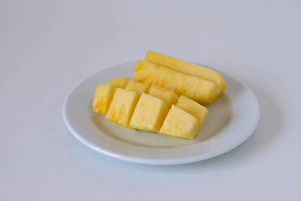 istock Pineapple slices in a white plate on white background 1314300761