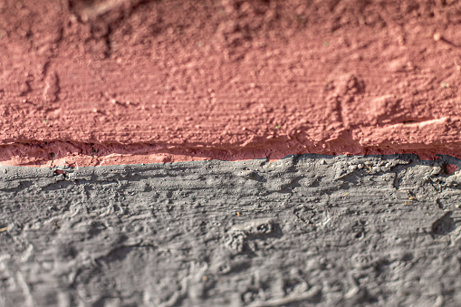 the concrete wall with a crack in the middle is painted in two juicy fashionable colors-gray and pink