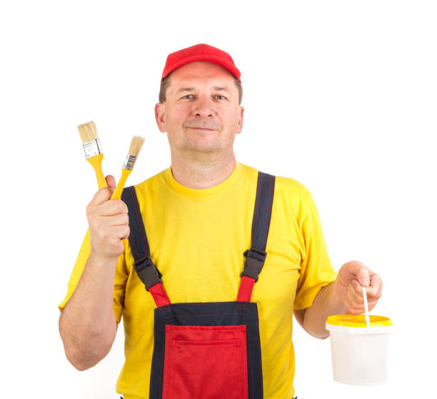 istock The worker holds brushes and a bucket of paint. 1314304903