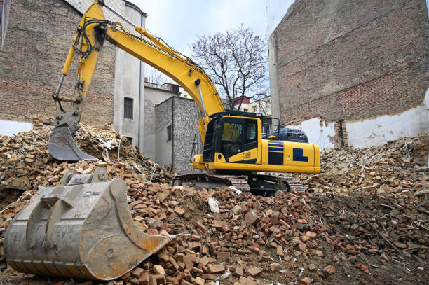 Earth moving machine tearing down an old building stock photo