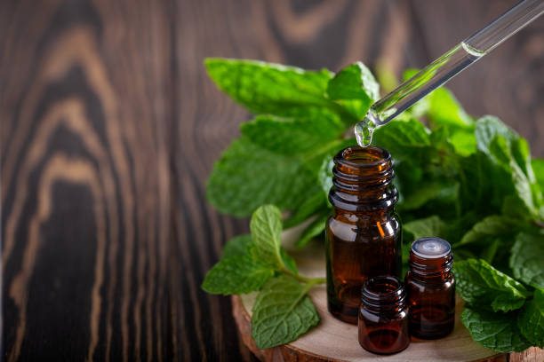 istock Essential oil falling from glass dropper into amber bottle 1314306686