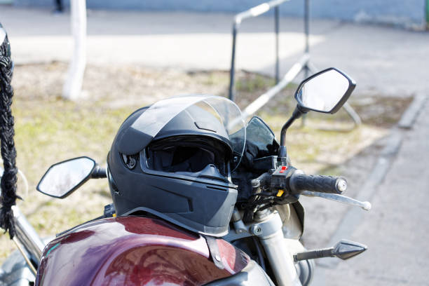 istock Closeup black moto helmet on motorcycle handlebars against blurred background 1314306957