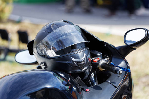 istock Closeup black moto helmet on motorcycle handlebars against blurred background 1314306964