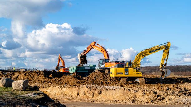 Construction site with excavator and bulldozer Berlin, Brandenburg, Germany - April 25, 2021: Amazon Germany builds a new Logistic Center next to Berlin Brandenburg. Construction sites with different construction machines like excavators, bulldozers, and trucks moving dirt on a sunny day with small clouds. shipping heavy agricultural machinery stock pictures, royalty-free photos & images
