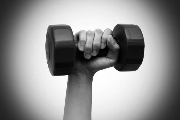 Woman's hand holding dumbbell on right hand. Black and white tone. Isolated on white background. Work out concept