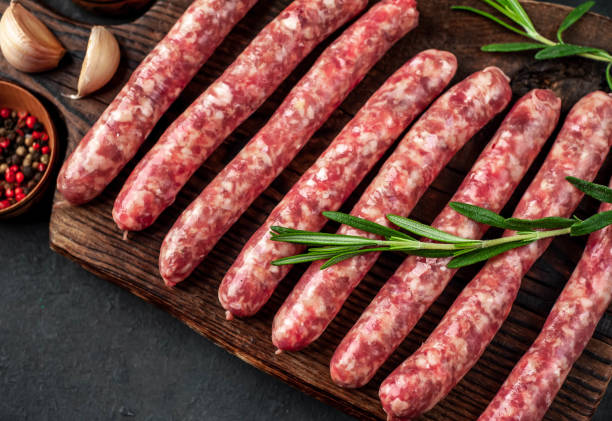 istock Raw sausages and ingredients for cooking on stone background 1314316289