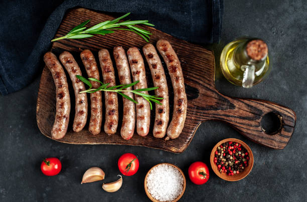 istock Grilled sausages with spices and rosemary on a stone table 1314316530