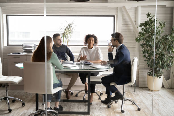 Diverse business people discussing project, brainstorming in modern board room
