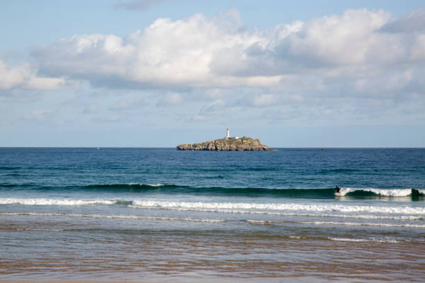 Surfer on Somo Beach with Mouro Island and Lighthouse in Background; Santander