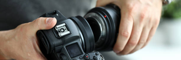 istock Male hands putting on modern digital camera professional lens 1314321995