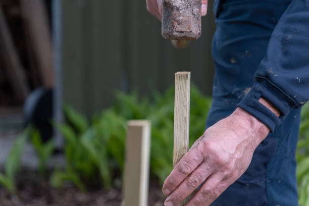 istock Using a sledgehammer a man drives wooden peg into the ground. 1314322413