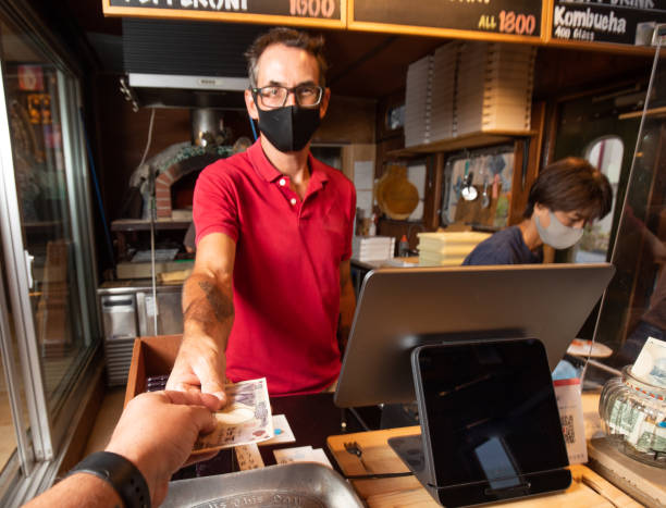 POV perspetive paying at a small home business resturant Focus on hands handing over money to pay for food at a small pizza restaurant. japan restaurant bill stock pictures, royalty-free photos & images