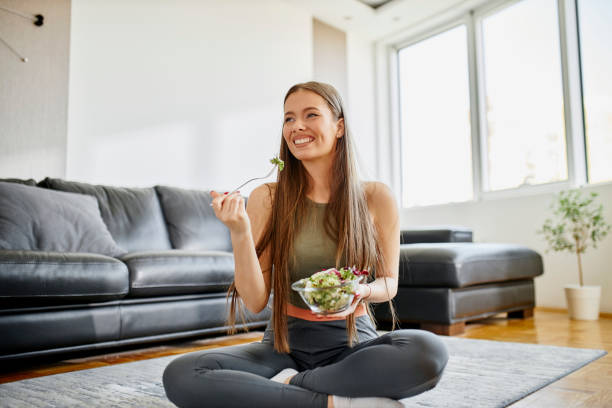 istock Fit woman eating fresh salad after intensive home workout 1314327727