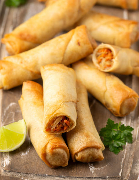 istock Fried vegetable spring rolls with sweet chili and soya sauce on wooden board 1314328059