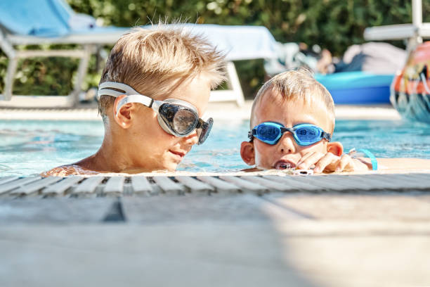 istock Little boys with swimming goggles have fun in hotel pool 1314330896