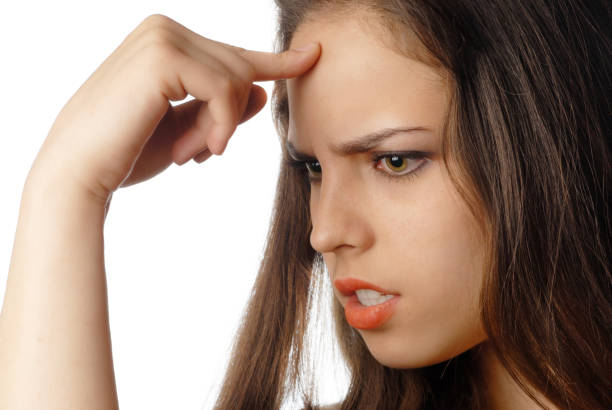 istock Young contemplative woman making a decision while holding a finger at her forehead 1314332301