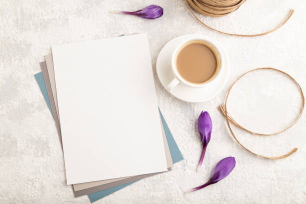 istock White paper sheet mockup with spring snowdrop crocus flowers and cup of coffee on gray concrete background. Blank, business card, top view, flat lay, copy space, still life. spring concept. 1314333707