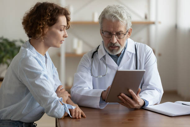 istock Serious middle aged doctor showing test results on tablet. 1314334450