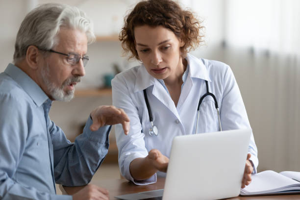 Confident young 30s female physician consulting old patient.