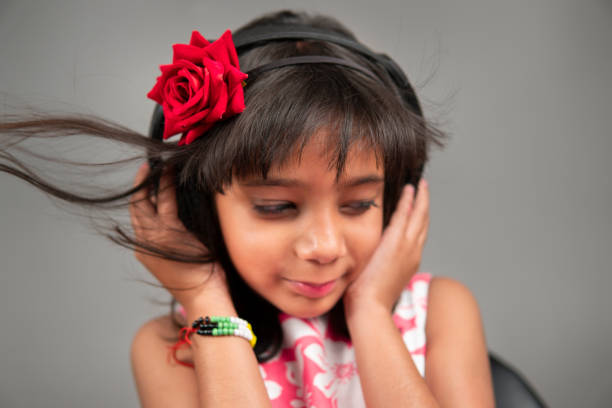 retrato de primer plano de una niña feliz escuchando música con auriculares. - blowing hair audio fotografías e imágenes de stock