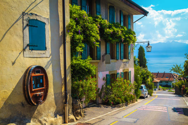 Rivaz village street view with flowery house and Geneva lake Traditional swiss house decorated with colorful flowers and beautiful street view. Rivaz village and Geneva lake in background, Canton of Vaud, Switzerland, Europe geneva switzerland stock pictures, royalty-free photos & images