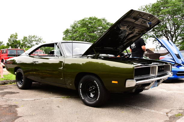 Dark green 1969 Dodge Charger R/T Mount Pleasant, Wisconsin / USA - July 21, 2019: On display at the local car show a 1969 dark green Dodge Charger R/T with a 440 Magnum motor in three quarter front view on an overcast summer day. dodge charger stock pictures, royalty-free photos & images