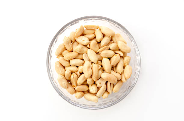 istock Roasted salted peanuts in a transparent glass bowl on a white background 1314339385