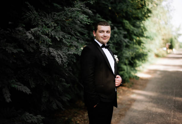 istock wedding day. Groom is staying and waking wearing black classic c 1314340397
