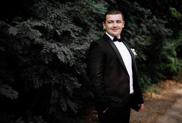 istock wedding day. Groom is staying and waking wearing black classic c 1314340410