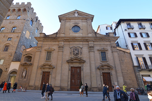 People walking down the holy Basilica of Santa Trinita, a gothic church in Florence historical centre, Italy