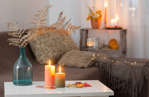 istock burning candles with autumn decor on white table at home 1314341136