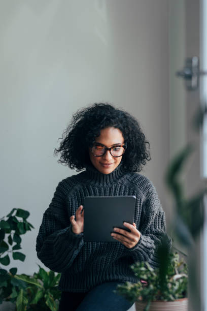 istock Working from Home: a Young Woman Using a Digital Tablet to ReadWatch Something (Vertical) 1314342015