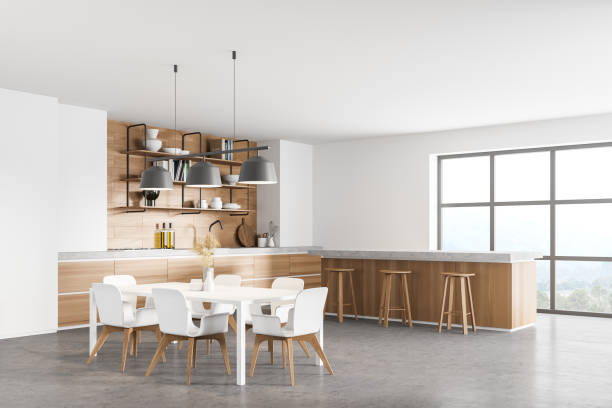 istock white modern kitchen near window. dining area with wooden countertop. Concrete floor. Panoramic windows. 1314345236